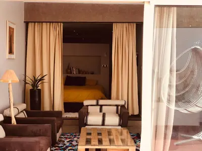 a living room with a couch and a bed at Du coté de chez Ikram in Marrakech