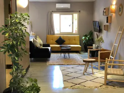 a living room with a yellow couch and chairs at Du coté de chez Ikram in Marrakech