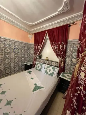 a bedroom with a bed with red curtains at chez Zaki in Marrakech