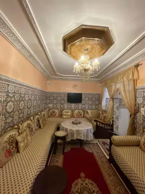 a living room with a table and a chandelier at chez Zaki in Marrakech