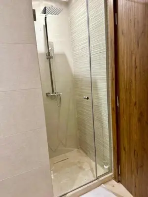 a shower with a glass door in a bathroom at Studio prestige in Marrakech