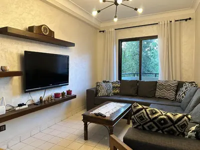 a living room with a couch and a flat screen tv at Elégance marrakech in Marrakech