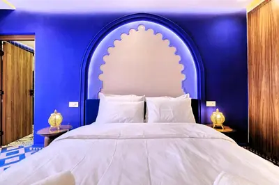 a bedroom with a large bed with a blue wall at Luxury Apartment Retreat in Marrakech in Marrakech