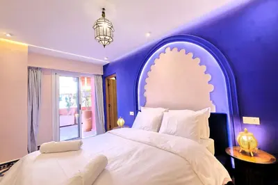 a bedroom with a large bed with a purple wall at Luxury Apartment Retreat in Marrakech in Marrakech