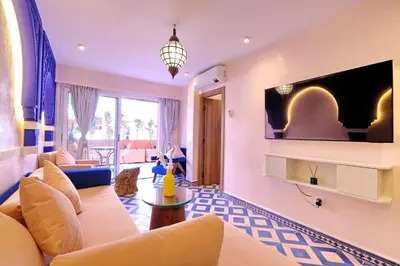 a living room with a couch and a tv on a wall at Luxury Apartment Retreat in Marrakech in Marrakech