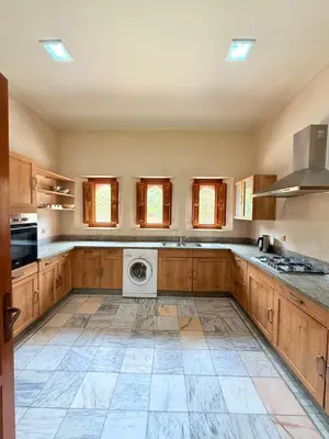 a large kitchen with wooden cabinets and a washer and dryer at VILLA 33 - 4 Master Suites, Stylish Moroccan Design & Private Pool in Marrakech