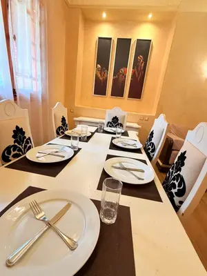a dining room table with white plates and silverware at VILLA 33 - 4 Master Suites, Stylish Moroccan Design & Private Pool in Marrakech
