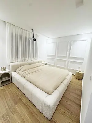 a white bedroom with a large bed with white curtains at Appartement de Luxe 3 Chambres avec piscine au centre in Marrakech