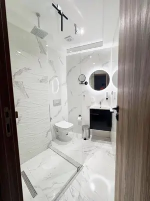 a white bathroom with a toilet and a sink at Appartement de Luxe 3 Chambres avec piscine au centre in Marrakech