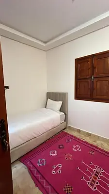 a room with a bed and a red rug at Riad Talal in Marrakech