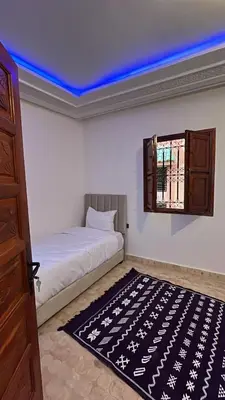 a bedroom with a bed and a blue ceiling at Riad Talal in Marrakech