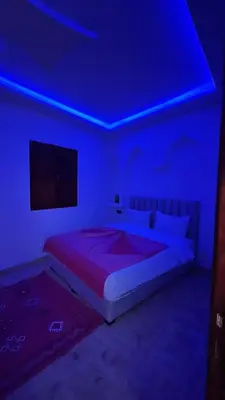 a bedroom with a bed with a blue light at Riad Talal in Marrakech
