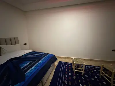 a bedroom with a bed and a blue rug at Riad Talal in Marrakech