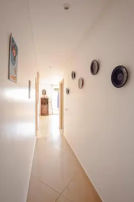 a white hallway with plates on the wall at Séjour confort jacuzzi et terrasse à Targa in Marrakech