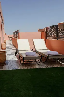 two chaise lounges on a balcony with green grass at Séjour confort jacuzzi et terrasse à Targa in Marrakech
