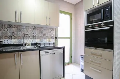 a kitchen with a sink and a microwave at Séjour confort jacuzzi et terrasse à Targa in Marrakech