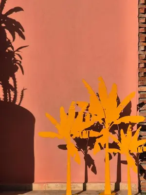 two palm trees in front of a red wall at Riad Beltza - 