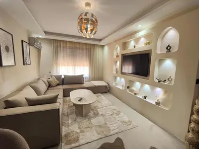 a living room with a couch and a tv at Appart Chic and Cosy, proche Gueliz in Marrakech