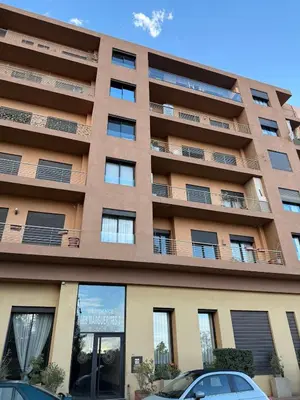 an apartment building with cars parked in front of it at Appart Chic and Cosy, proche Gueliz in Marrakech
