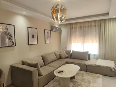 a living room with a couch and a table at Appart Chic and Cosy, proche Gueliz in Marrakech