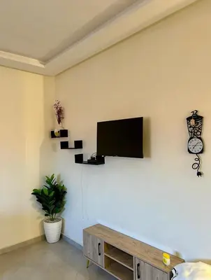 a living room with a flat screen tv on a wall at Residence Jnane Tissir Marrakech in Marrakech