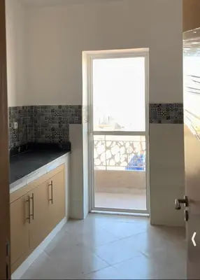 a kitchen with a door leading to a balcony at Residence Jnane Tissir Marrakech in Marrakech