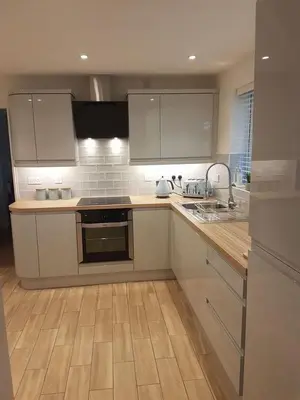 a kitchen with white cabinets and a wooden counter top at Dar lhssn in Marrakech