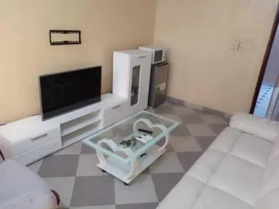 a living room with a tv and a couch at Dar lhssn in Marrakech