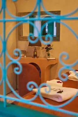 a room with a table and a chair and a mirror at Riad Lia ou Lik in Marrakech