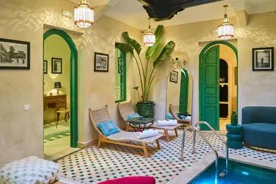 a living room with a blue couch and chairs at Riad Lia ou Lik in Marrakech