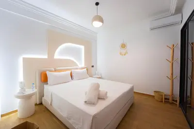 a white bedroom with a white bed with white pillows at Gueliz Central Apartment with Pool and Parking in Marrakech