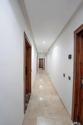 an empty hallway with white walls and wooden doors at Gueliz Central Apartment with Pool and Parking in Marrakech