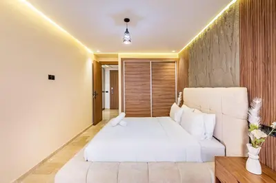 a bedroom with a white bed and a couch at Luxury 1BR in gueliz in Marrakech