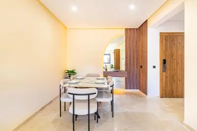 a dining room with a table and chairs at Pool views 2BR family apartment in Marrakech