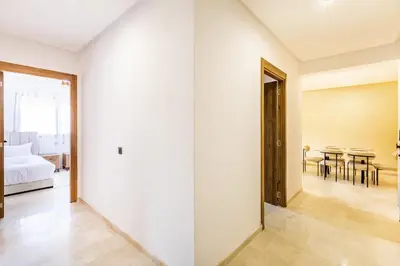 a white room with a bed and a table at Pool views 2BR family apartment in Marrakech