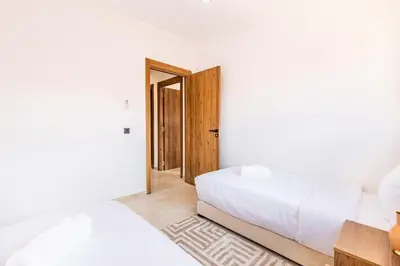 a bedroom with two beds and an open door at Pool views 2BR family apartment in Marrakech