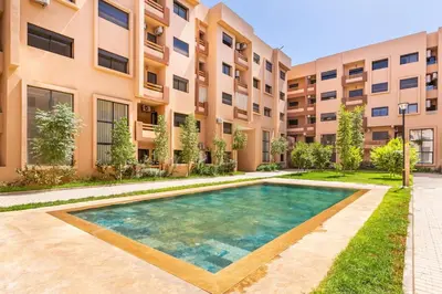 an apartment complex with a swimming pool in front of a building at Pool views 2BR family apartment in Marrakech