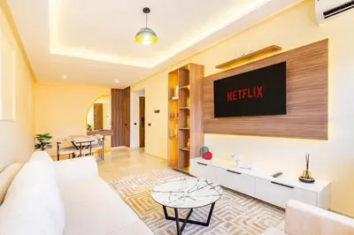 a living room with a couch and a tv on the wall at Pool views 2BR family apartment in Marrakech