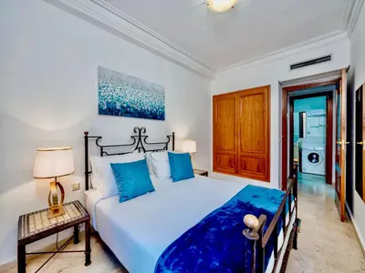 a bedroom with a large bed with blue pillows at Majorelle Appartement - Balcony and Netflix in Marrakech