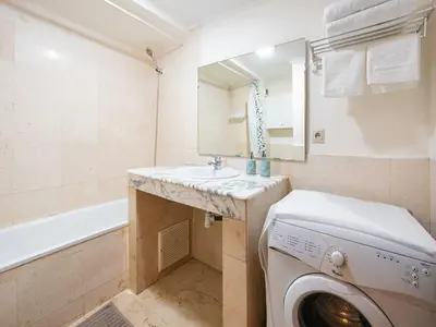 a bathroom with a washing machine and a sink at Majorelle Appartement - Balcony and Netflix in Marrakech