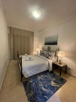 a bedroom with a large bed and a blue and white rug at Majorelle Appartement - Balcony and Netflix in Marrakech