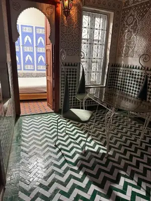 a room with a table and chairs and a door at Amber in Marrakech
