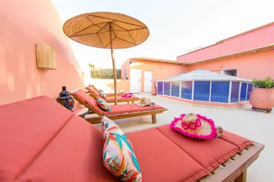 a patio with two chairs and an umbrella at Riad Dahab in Marrakech