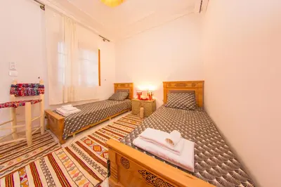 a bedroom with two beds and a window at Riad Dahab in Marrakech