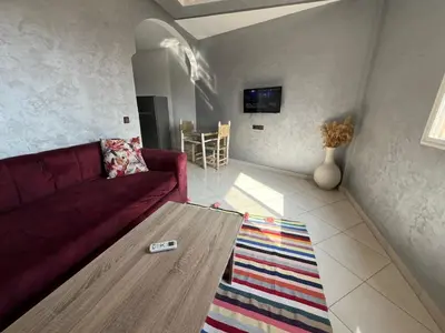 a living room with a red couch and a table at Appart hotel ali in Marrakech