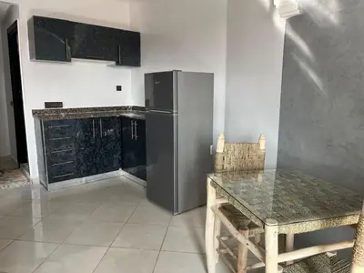 a kitchen with a table and a stainless steel refrigerator at Appart hotel ali in Marrakech