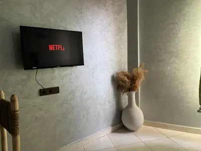 a white vase sitting in front of a tv at Appart hotel ali in Marrakech