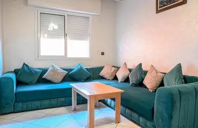 a blue couch in a living room with a table at Appart hotel ali in Marrakech