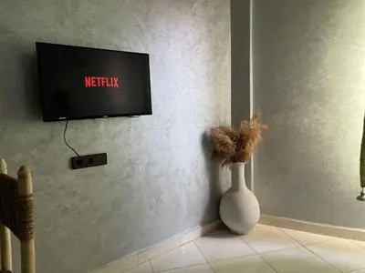 a white vase sitting in a room with a tv at Appart hotel ali in Marrakech