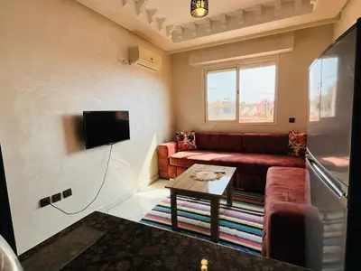a living room with a couch and a tv at Appart hotel ali in Marrakech